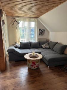 a living room with a couch and a table at Privatzimmer bei Renate am Grünen See in Ratingen
