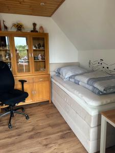 a bedroom with a bed and a desk and a chair at Privatzimmer bei Renate am Grünen See in Ratingen