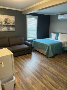 a bedroom with a bed and a couch at Stanley House Motel in Clarenville +14 photos