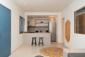 a kitchen with a counter and two stools in a room at Gianemma Luxury Apartments in Mylopotas