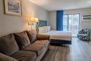 un salon avec un canapé et un lit dans l'établissement Recently Updated Oceanview King Suite! Sea Mist 50504! Sleeps 4!, à Myrtle Beach
