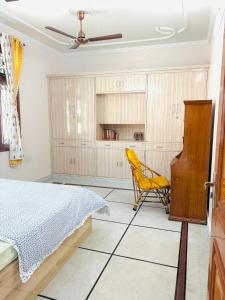 a bedroom with a bed and a yellow chair at The Royal retreat in New Delhi