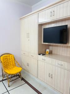 a yellow chair in a room with a tv at The Royal retreat in New Delhi +37 photos