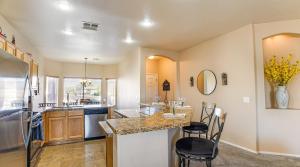 a kitchen with a counter and chairs in a room at 120th Avondale in Avondale