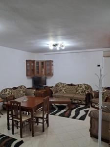 Apartments Keesi 3 Durrës في دوريس: غرفة معيشة مع أرائك وطاولة وكراسي
