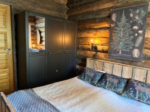 Un dormitorio con una cama en una cabaña de troncos en VillaAngie Ruka, en Ruka