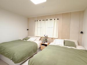 a bedroom with two beds and a window at Doors Seongsu in Seoul