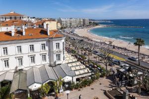 une vue d'une plage avec un bâtiment et l'océan dans l'établissement Promenade des Bains Apartment, à Saint-Raphaël