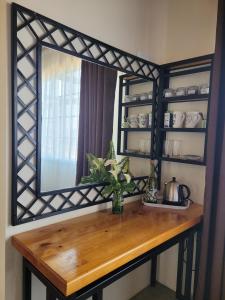 a mirror on a wall with a wooden table at Ouma se Huis in Tierpoort +1 photo