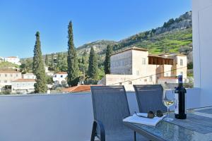 a table with a bottle of wine and a glass at Aori Guest House II in Hydra