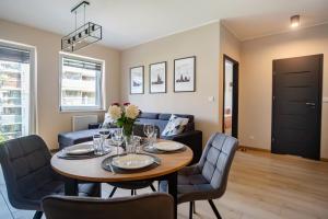 ein Esszimmer und ein Wohnzimmer mit Tisch und Stühlen in der Unterkunft Poznań Jeżyk-Luxury Apartment Free Parking in Posen