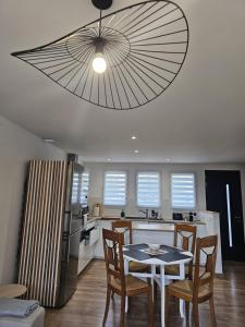 a dining room and kitchen with a table and chairs at Le Jean Zay climatisation parking privé in Montauban