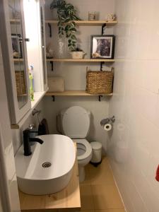 a bathroom with a white sink and a toilet at La casita de Kalani in Comillas +8 photos