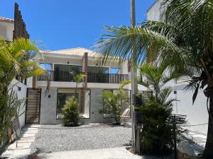 a house with palm trees in front of it at Villa Darius in Cabo Frio