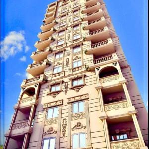 a tall building with balconies on the side of it at Apartament Villal Banha in Kafr al Jazzār