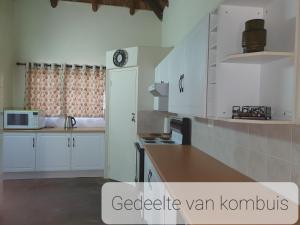 a kitchen with white cabinets and a counter top at Ouma se Huis in Tierpoort