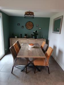 a dining room with a wooden table and chairs at Hébergement le Mans in Le Mans