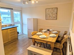 a kitchen and dining room with a wooden table at Theatre Severn Town House, Parking & Quarry Views in Shrewsbury