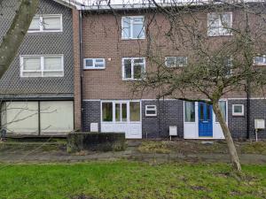 a brick house with white garage doors and a tree at Theatre Severn Town House, Parking & Quarry Views in Shrewsbury