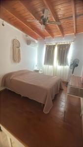a bedroom with a bed and a ceiling fan at Carpediemch in Chascomús +15 photos