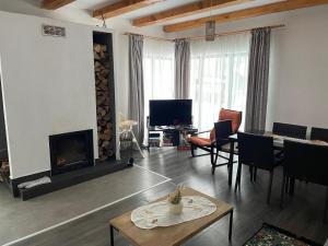 a living room with a fireplace and a tv at Odăile Craiului in Şirnea