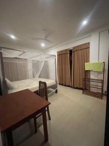 a small room with a bed and a table and a table sidx sidx at Villa Wanderlust in Hikkaduwa