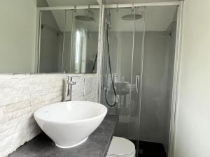 Un baño con lavabo, ducha e inodoro. en SUNSET HOUSe AIR CON Large Balcony, Unbeatable view and Peace, en Perledo