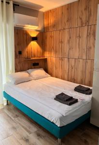 łóżko w pokoju z drewnianą ścianą w obiekcie VILLA LIGHTHOUSE - Adults Only - 12plus w mieście Krynica Morska