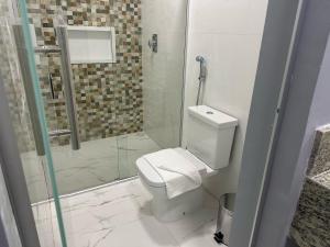 a bathroom with a toilet and a glass shower at Hotel Premier in Belo Horizonte