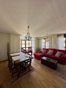 a living room with a red couch and a table at Cuevas del Mar in Nueva de Llanes