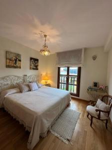 a bedroom with a large white bed and a chandelier at Cuevas del Mar in Nueva de Llanes