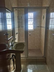 a bathroom with a shower and a sink at Savannah Guest House Mafikeng in Mahikeng
