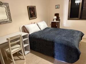 een slaapkamer met een bed met een blauwe deken bij Casa Vivien in Cotillo