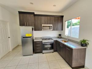 a kitchen with wooden cabinets and stainless steel appliances at Casa Perla in El Rosario +19 photos