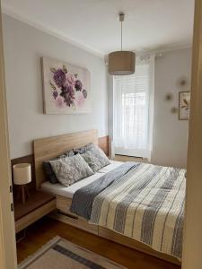 a bedroom with a bed and a window at Manila Apartment in Belgrade