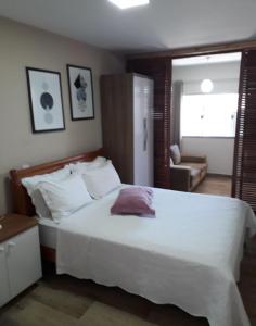 a bedroom with a large white bed and a chair at Espaço Kayan in Cunha