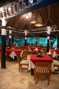 a restaurant with tables and chairs with red table cloth at Platon Ecolodge in Santa Cruz de Barahona