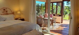 ein Schlafzimmer mit einem Bett und einer Glasschiebetür in der Unterkunft Garden Cottage at Casa Madden in Marbella + 30 Fotos