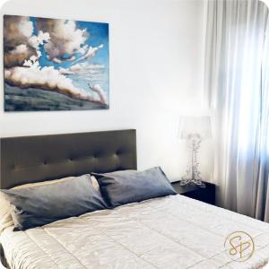 サレルノにあるSalerno Place - Design Houseの壁に絵が飾られたベッドのある寝室