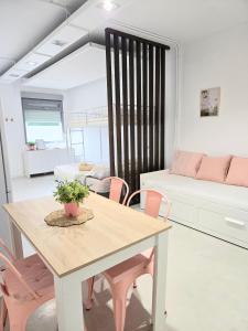 a living room with a table and pink chairs at Little love in Hospitalet de l'Infant
