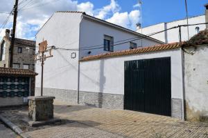 un edificio blanco con una puerta negra en una calle en Villamaría, Alma de Despeñaperros, en Miranda del Rey 29 fotos más
