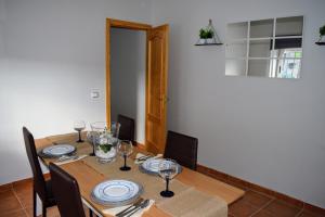 Un comedor con una mesa con platos y copas de vino. en Villamaría, Alma de Despeñaperros, en Miranda del Rey