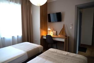 pokój hotelowy z dwoma łóżkami i biurkiem z telewizorem w obiekcie 4jeziora - prywatny dostęp do rzeki, pomost, ogrodem, wiata grillowa, rowerek wodny, kajaki i SUP w cenie, parking, psiaki dozwolone w Iławie
