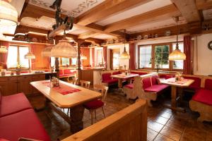 a restaurant with wooden tables and red chairs at Alpen Hotel Martin in Nesselwang