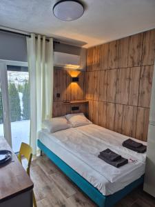sypialnia z łóżkiem i drewnianą ścianą w obiekcie VILLA LIGHTHOUSE - Adults Only - 12plus w mieście Krynica Morska