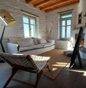 a living room with a couch and a chair at ARIA Kea Sunset Homes in Milopótamos