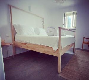 a bed with a wooden frame in a bedroom at ARIA Kea Sunset Homes in Milopótamos