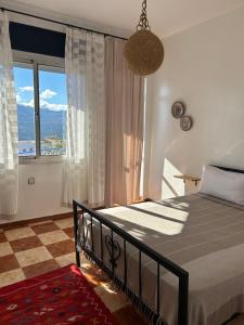 una camera da letto con un letto e una grande finestra di Hotel Al Manar a Chefchaouen
