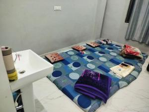 a room with a bed on the floor next to a sink at Annpurna Apartment in Varanasi