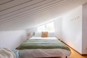 Un dormitorio con una cama en una habitación blanca. en Spaziosa Villa con piscina, BBQ e campi da tennis, en Casal Palocco 52 fotos más